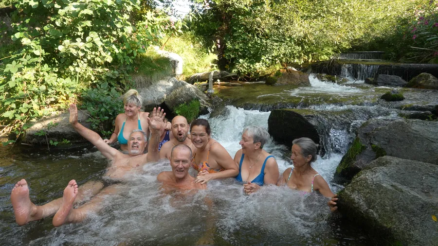 Gemischte Gruppe beim Eisbaden im Fluss während eines Mentaltraining Retreats - medium Fröhliche Gruppe beim Eisbaden und Kältetraining im Fluss während eines Mentaltraining Retreats in Österreich