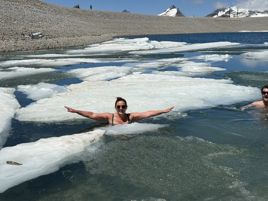 Frau genießt Eisschwimmen Retreat Österreich im Gletschersee mit Eisschollen