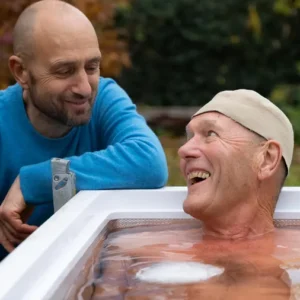 Lachender Mann im Eisbad beim Kältetraining Wien Workshop, betreut von einem Coach für Mentaltraining