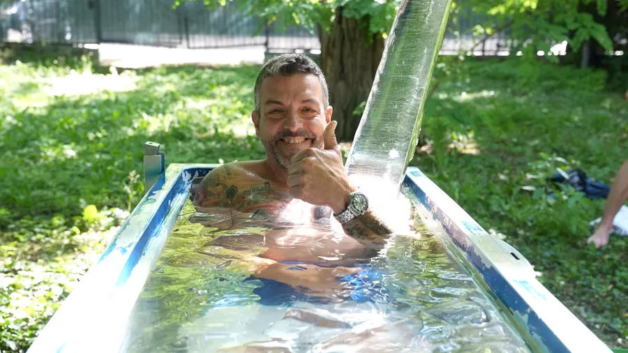 Lachender Mann im Eisbad zeigt Daumen hoch beim Kältetraining Wien Workshop für mentale Stärke