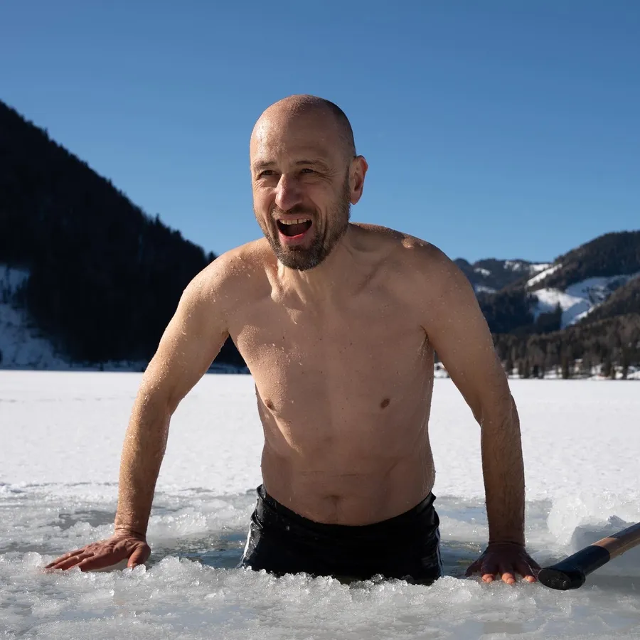 Eisbaden Coach Österreich Marcus Bernhardt steigt energiegeladen aus einem Eisloch im Erlaufsee nach dem Kältetraining