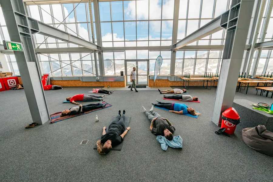 Gruppe beim Atemtraining und Breathwork Workshop Alpen in einem verglasten Raum am Mölltaler Gletscher