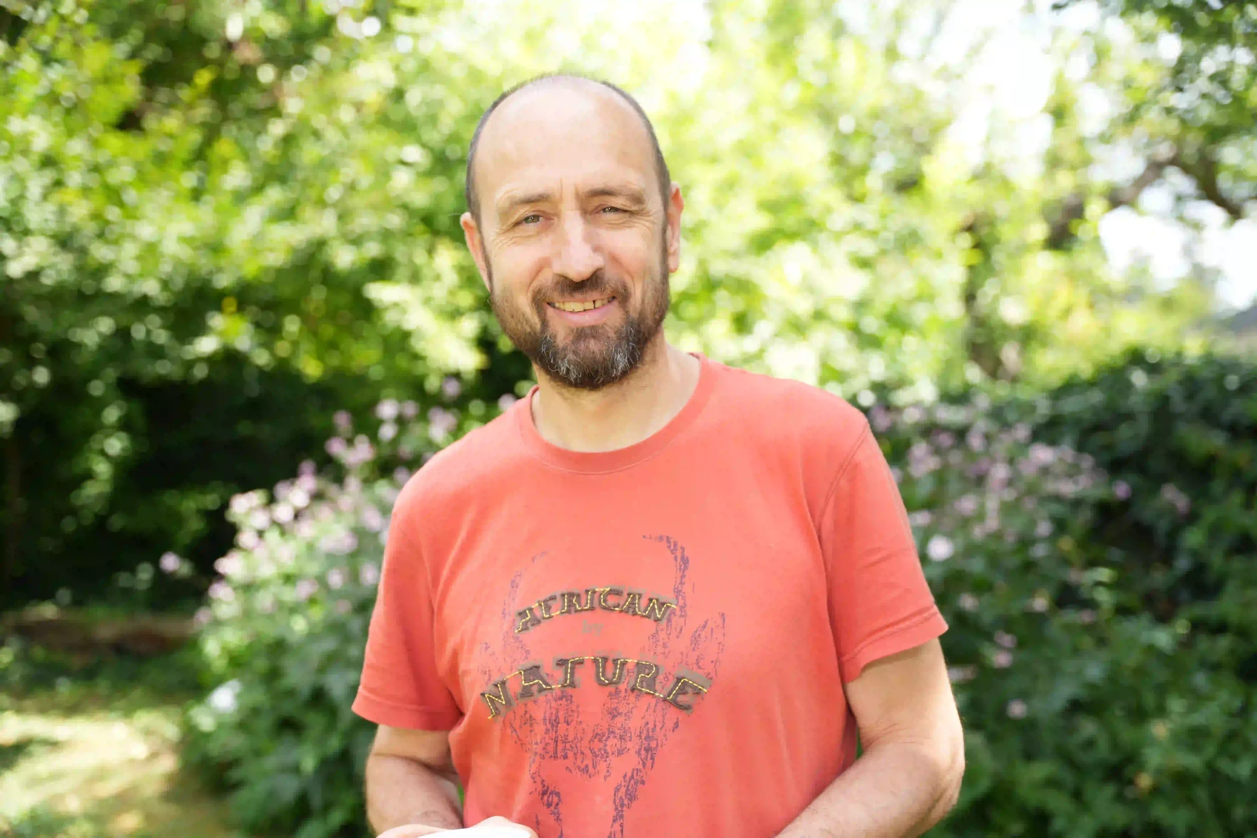 Der zertifizierte mindest Coach Marcus Bernhardt steht fröhlich im Garten und freut sich auf seine nächsten Coachings.